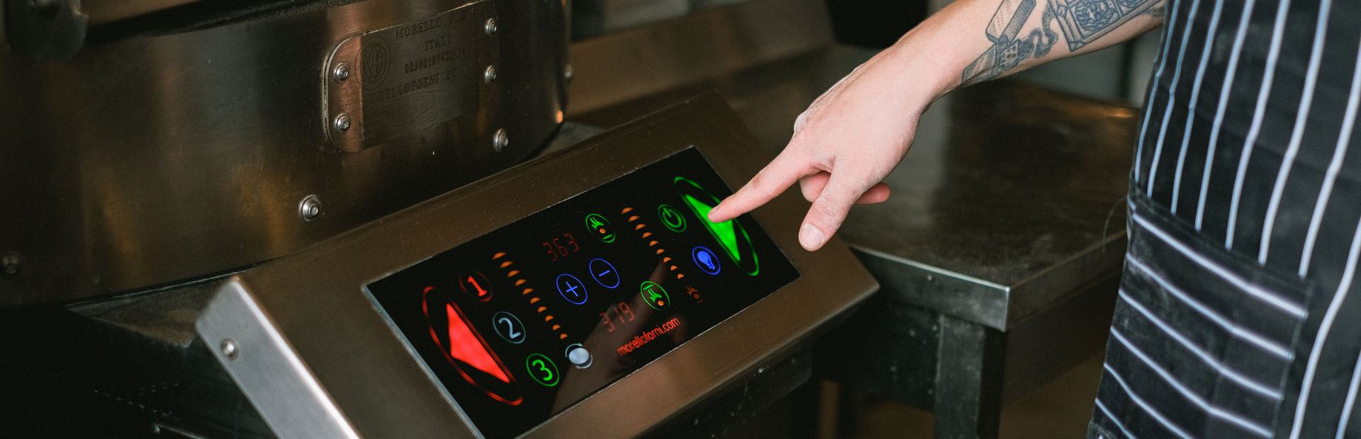Hand pressing an illuminated membrane keypad on a machine control panel