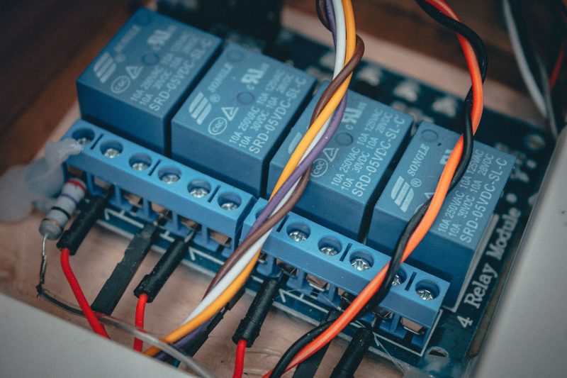 Relay modules wired to a terminal block inside a control panel