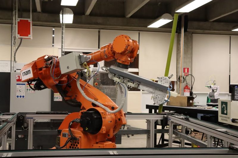 Orange six-axis industrial robot arm mounted on a workbench