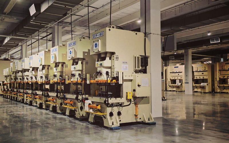 Row of industrial stamping presses on a mill floor