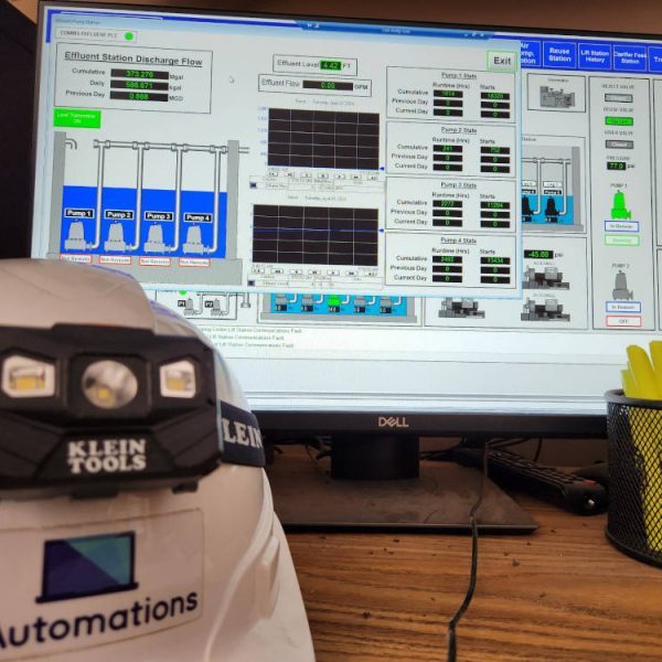 SCADA screen showing effluent station discharge flow, with an i3Automations hard hat in the foreground