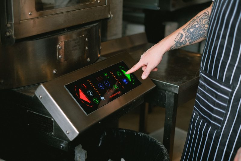 Hand pressing an illuminated membrane keypad on a machine control panel